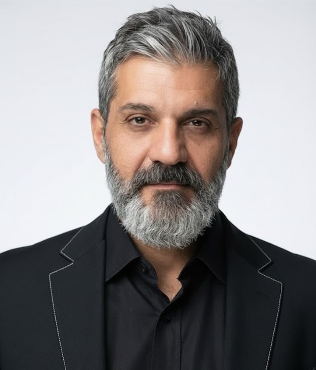 Sean, founder of Dolca Sugar, studio portrait in a black shirt and blazer